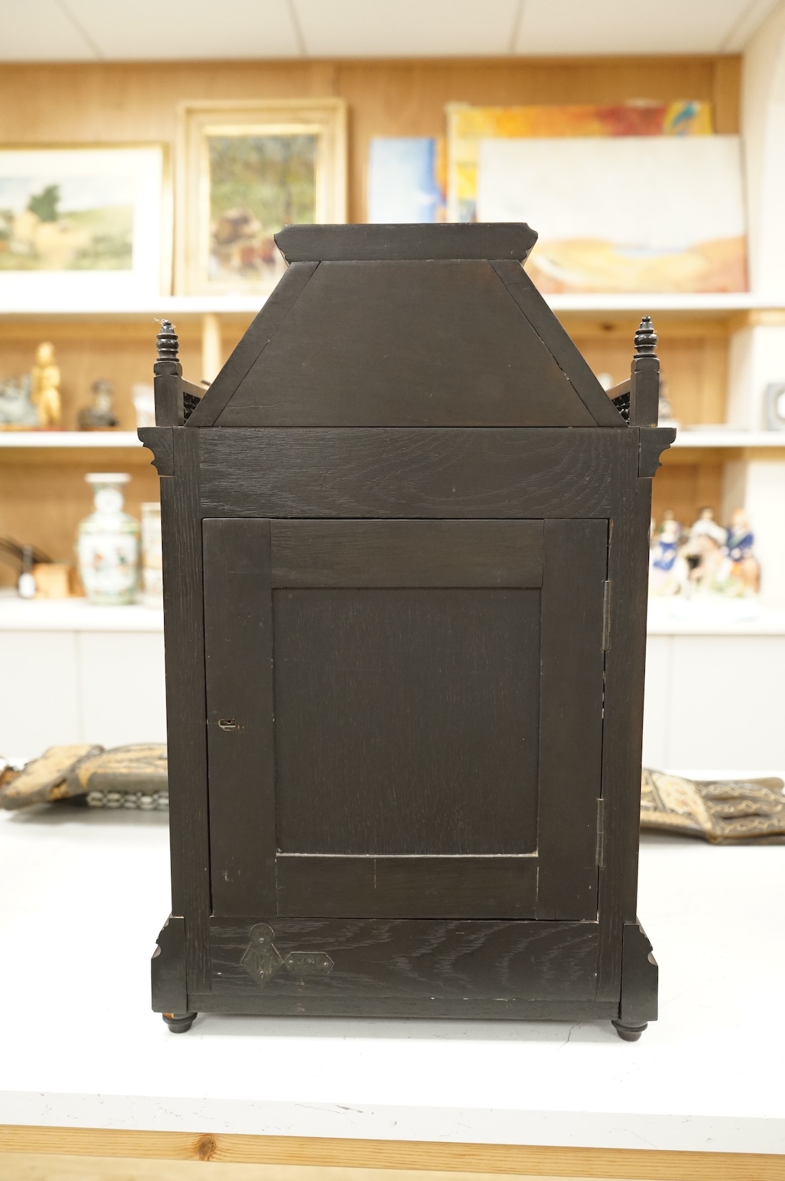 A Victorian Aesthetic Movement ebonised architectural mantel clock, probably designed by Lewis Foreman Day, the eight day chiming movement marked G.V. no. 39837, with Elourdelet lever, with figure and foliage decorated g